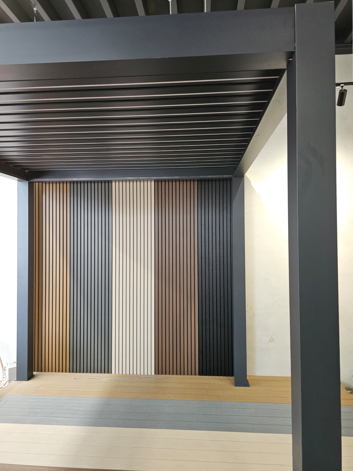 Wooden paneling with horizontal slats in various colors on a wall.