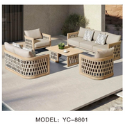 Outdoor furniture set with beige sofa, chairs, and coffee table on a patio.