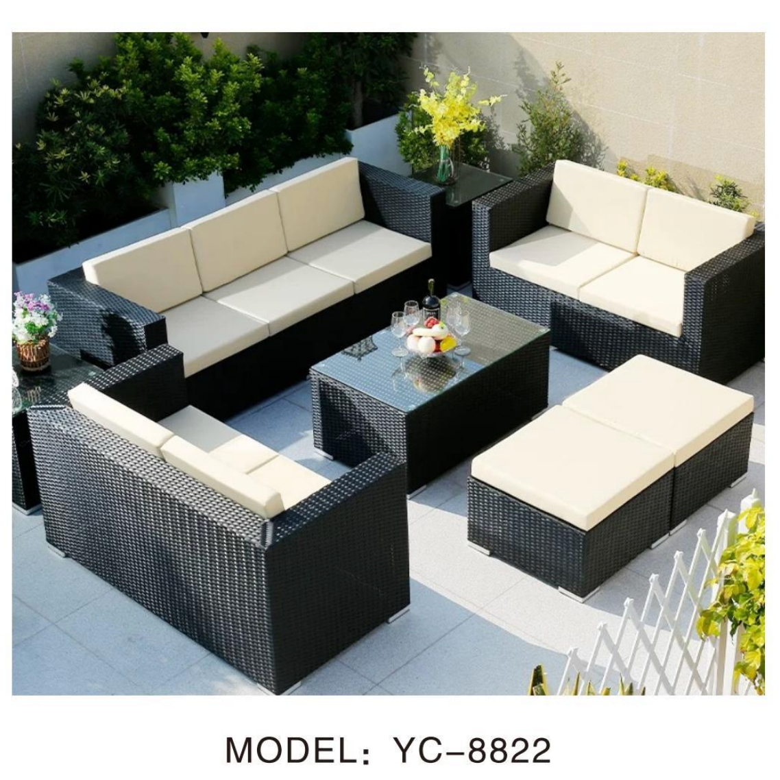 Outdoor patio furniture set with beige cushions on a patio with plants and a table.