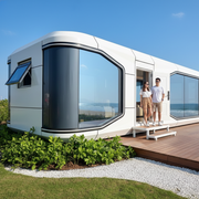 Modern prefab house with a view of the ocean on a sunny day