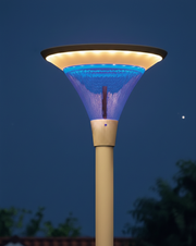 An ultra-refined, close-up shot of a modern architectural street lamp at night. The fixture features a sleek funnel-shaped design with a warm golden glow at the top, a vibrant electric-blue crystalline interior, and high-quality metallic finish on the pole, set against a dark blue twilight sky with subtle stars.