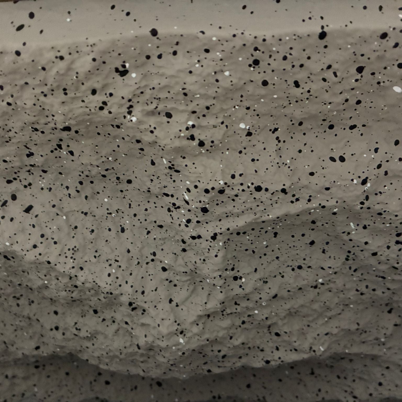 Close-up of a textured concrete surface with black specks